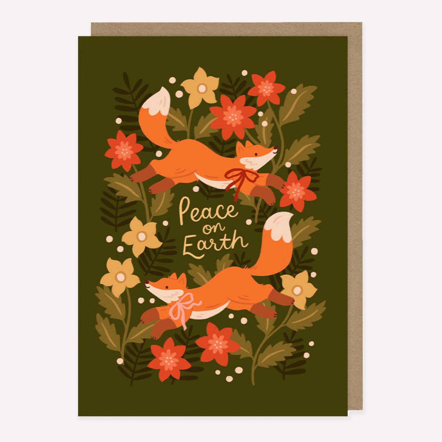 Illustrated Christmas greetings card featuring two foxes and winter foliage on a green background with handwritten text reading "peace on earth".