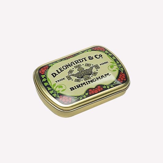 D.leondardt & Co. vintage-inspired calligraphy dip pen storage tin printed with a copy of the original crest design. This brass storage tin has curved edges and a friction closure, perfect for storing nibs between creative projects. 