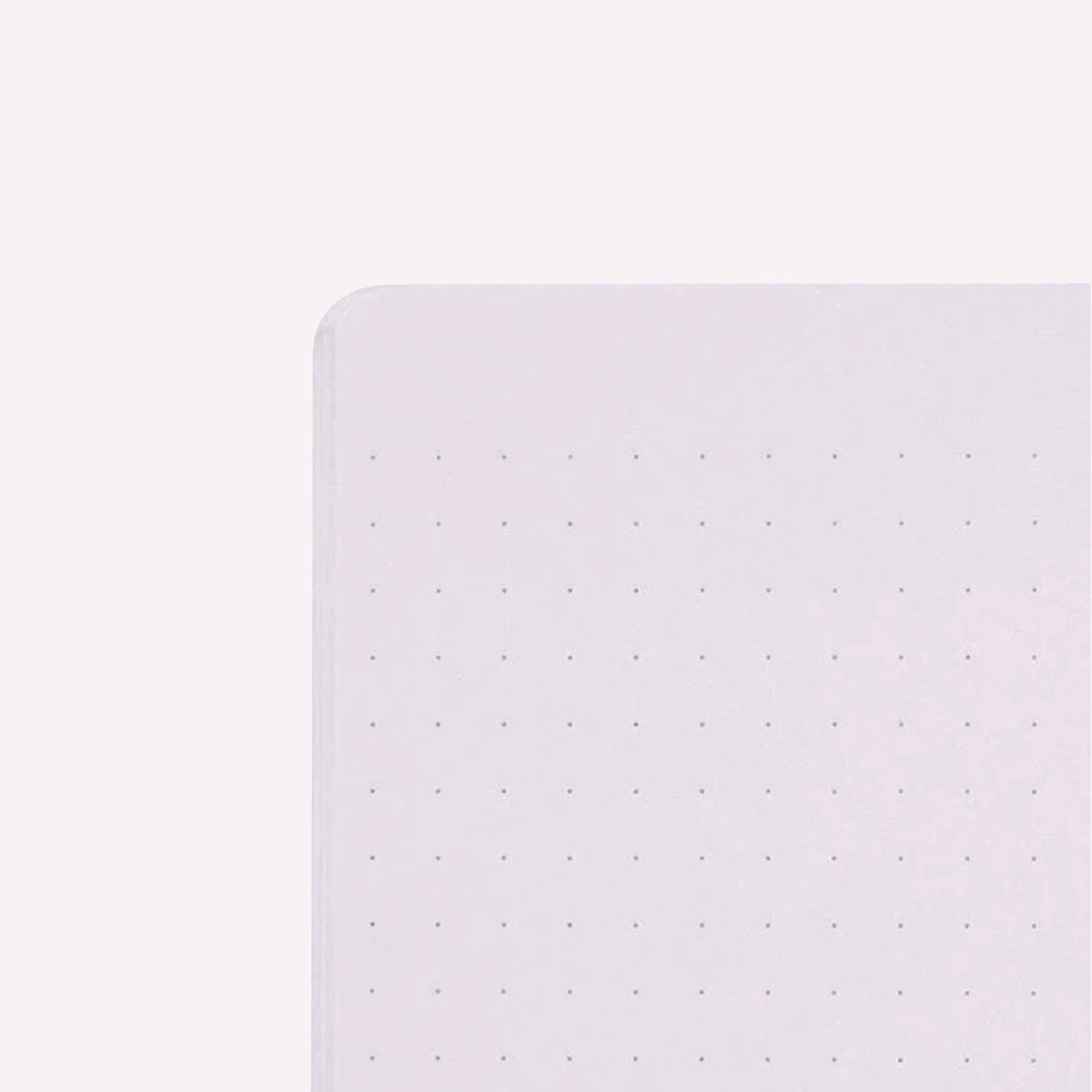 Inside corner of a page of the midori soft cover stapled notebook. Pages are pale purple with a subtle dot grid (5mm spacing).