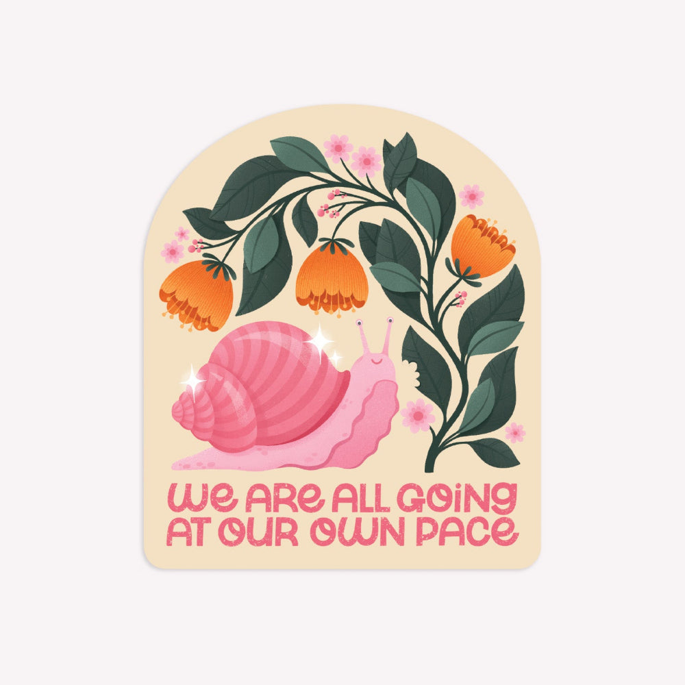 Illustrated arch-shaped sticker with featuring a snail and a flowering plant, with text below reading "We Are All Going At Our Own Pace".