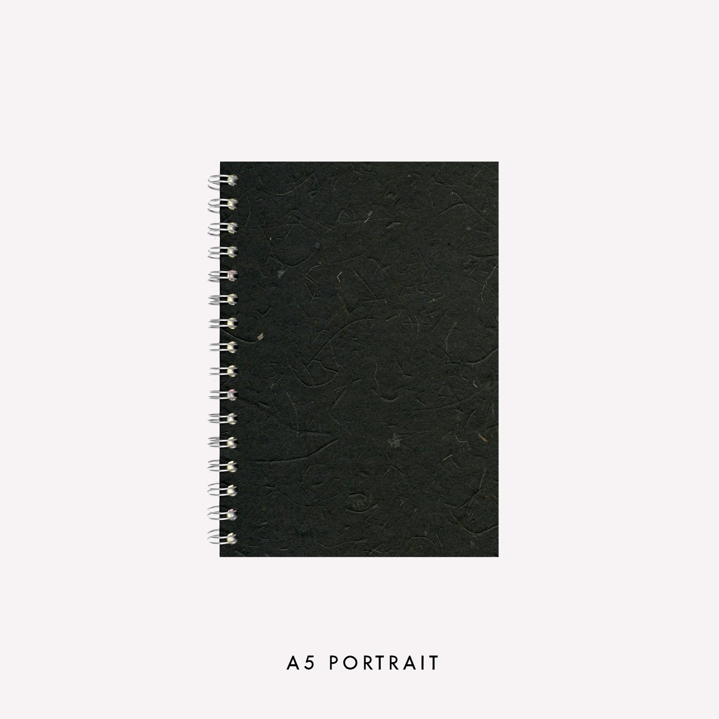 A5 wire bound portrait sketchbook made in the UK by Pink Pig with an ebony coloured banana tissue paper cover and strudy grey board backing.