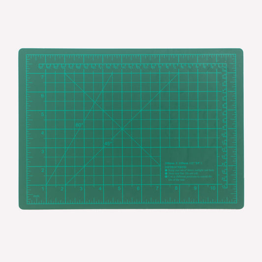 Green A4 cutting mat printed with a measuring grid for precise cutting work.