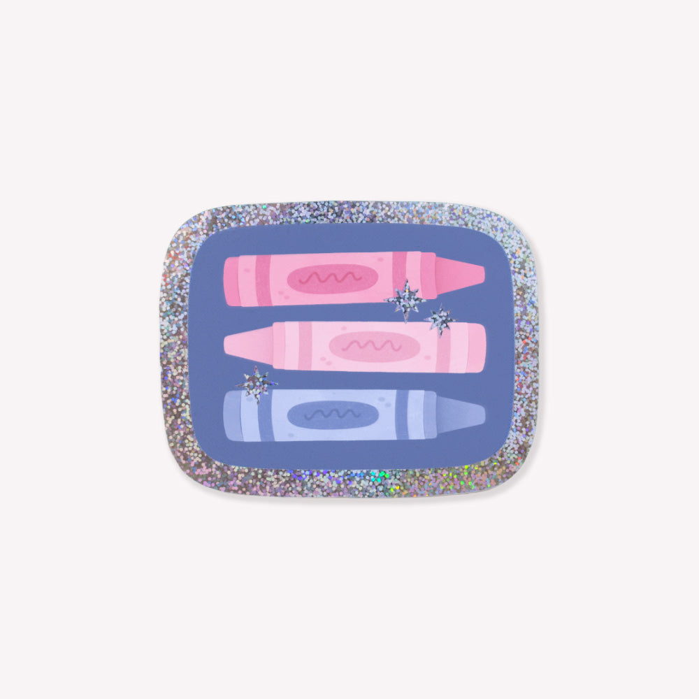 Sparkly sticker with an illustration of three crayons on a blue background with a glittery outline and star details.