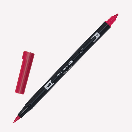 Tombow ABT Dual brush pen in Crimson (847) with open caps showing a fine tip for details and a brush tip for expressive marks.
