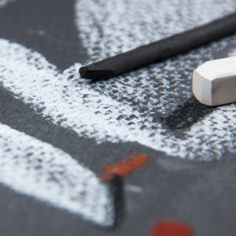 Winsor and Newton A4 pastel paper pad with assorted grey paper. Lifestyle photos shows and example drawing of white chalk on the grey textured paper.