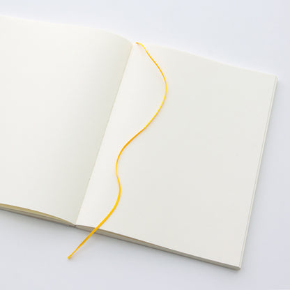 MD Paper A5 notebook open flat on a table to show the ribbon page marker. 