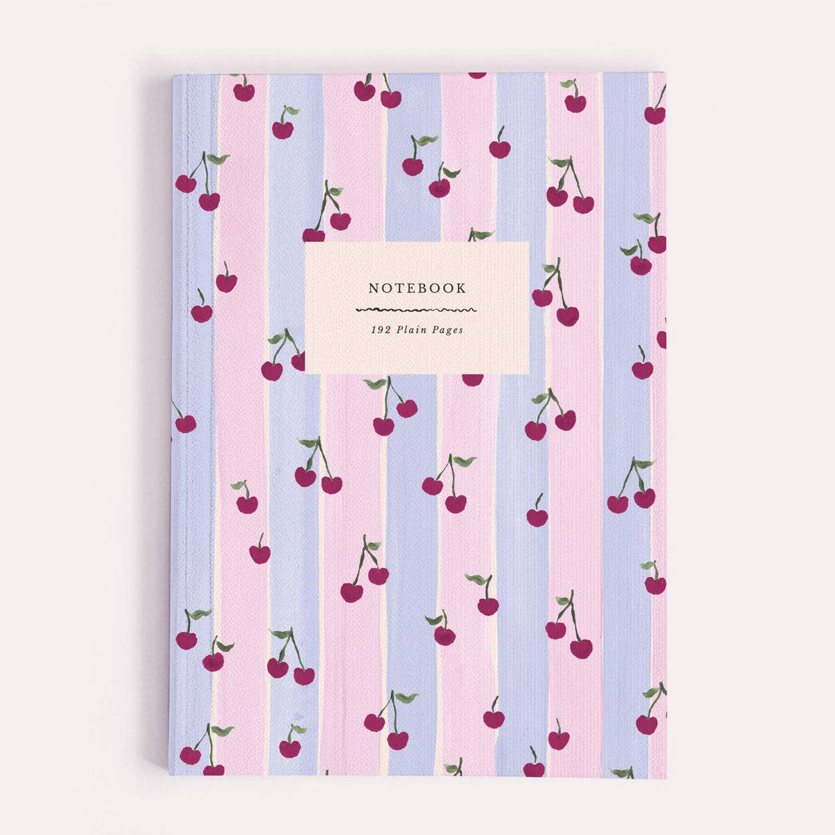 A plain paper notebook by Sister Paper Co, illustrated with a pattern of red cherries and pastel pink and blue stripes.