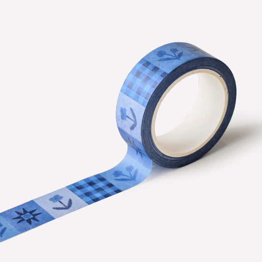 Roll of paper washi tape designed by Claire Paul, featuring a navy blue pattern of flowers and stars.