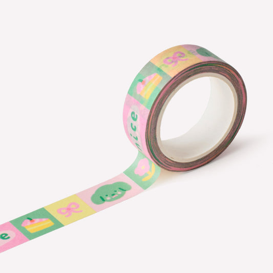 Roll of paper washi tape designed by Claire Paul, featuring a pattern of charms and trinkets in bright green, pink and yellow colours.