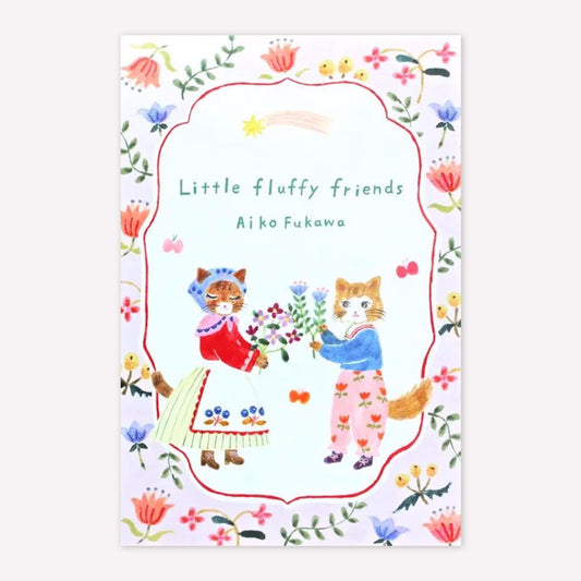 Front cover of Cozyca Aiko Fukawa postcard pad set with an illustration of two cats holding flowers within a pink floral border. 