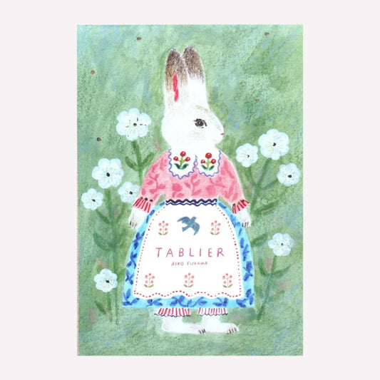 Front cover of the Cozyca Aiko Fukawa postcard pad set, featuring a bunny character design on green background surrounded by flowers. 