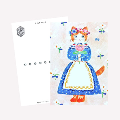 Cozyca Aiko Fukawa postcard design featuring a cat character dressed in a cute outfit holding bouquet on a soft pink meadow background. The reverse features a postcard design with space to write a message. 