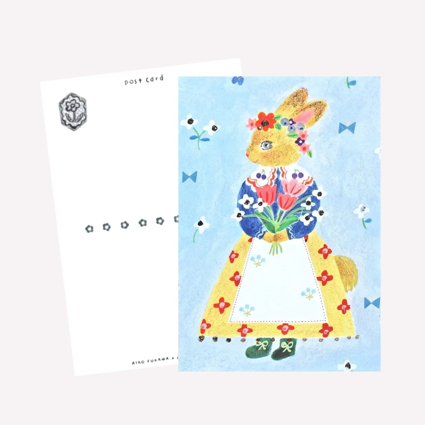 Cozyca Aiko Fukawa postcard design featuring a bunny character dressed in a cute outfit holding bouquet on a blue floral background. The reverse features a postcard design with space to write a message. 
