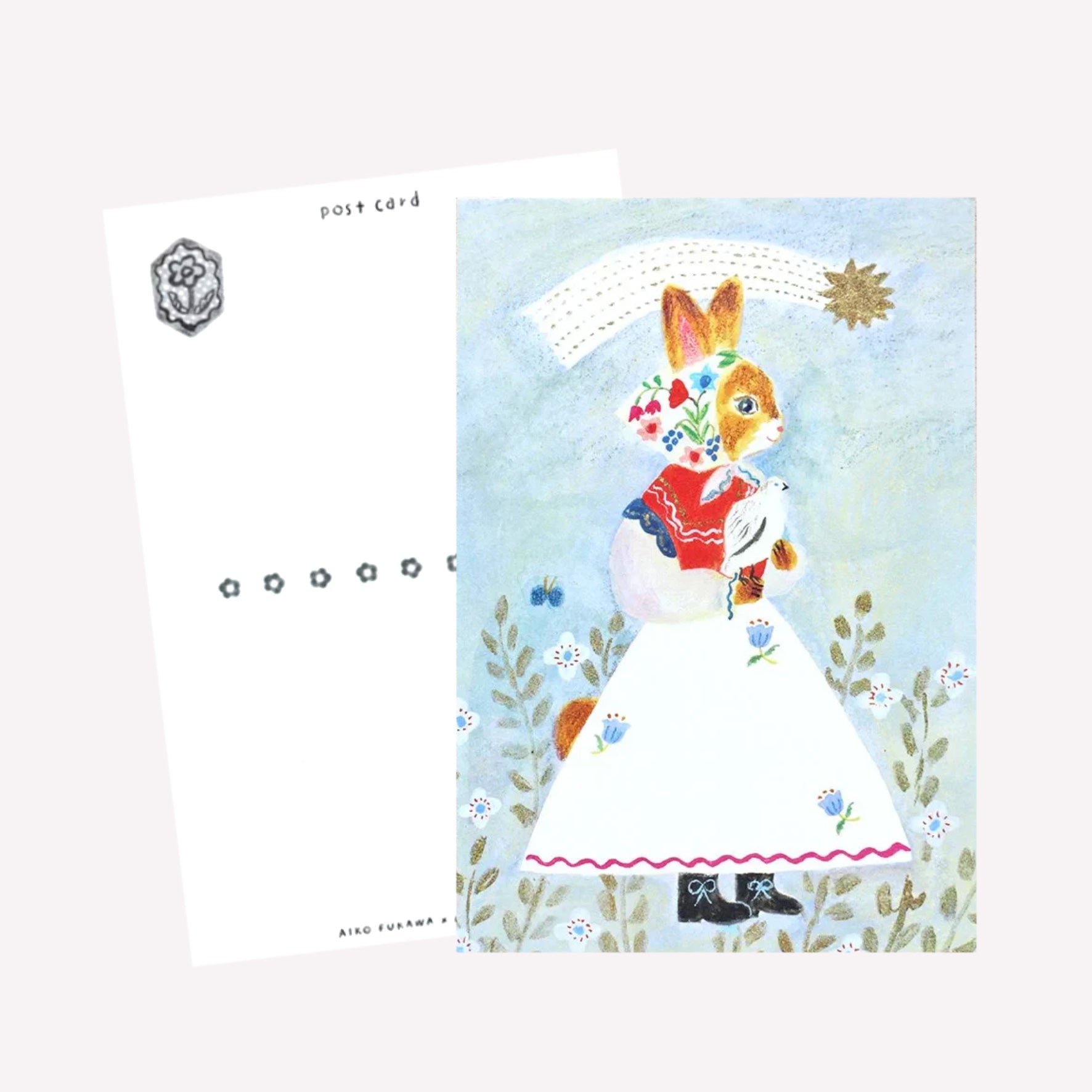 Cozyca Aiko Fukawa postcard design featuring a cat character dressed in a cute outfit holding a bird under a shoorting star on a blue background. The revers features a postcard design with space to write a message. 