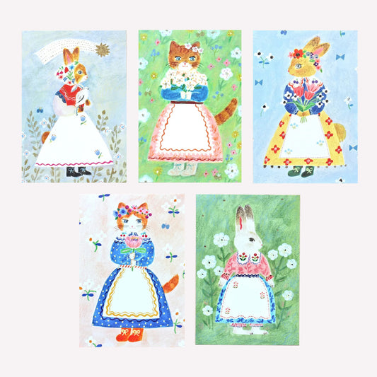 Cozyca Aiko Fukawa Tablier postcard designs featuring 5 illustrations of animals wearing cute outfits holding flowers on a meadow style background. 
