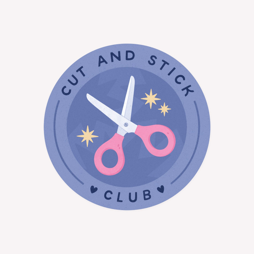 Illustrated, circular sticker featuring a pink pair of scissors on a purple background, circled by the words "Cut And Stick Club".