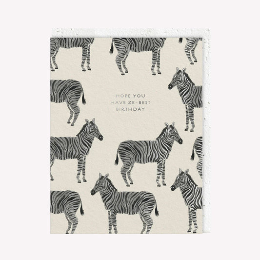 An illustrated greetings card by Seedlings, printed by Ohh Deer. This card features a pattern of zebras, with text that reads “Hope You Have Ze-Best Birthday”.