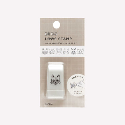 Matoka Deco Loop Stamp of cats faces, packaged with a grid background. 