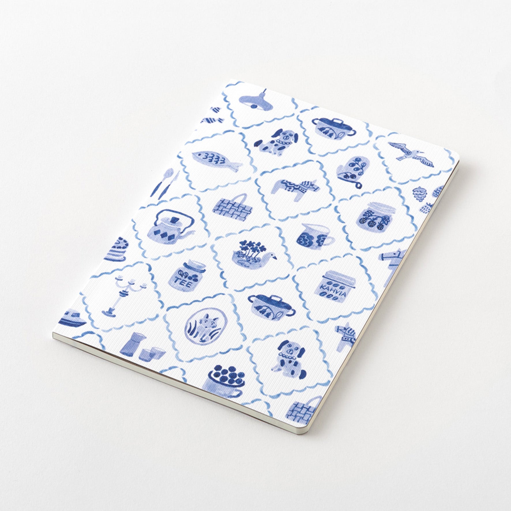 Midori Blue Nordic Yuru Log notebook with a pattern of scandinavian motifs on the cover, lying flat on the a white table. 