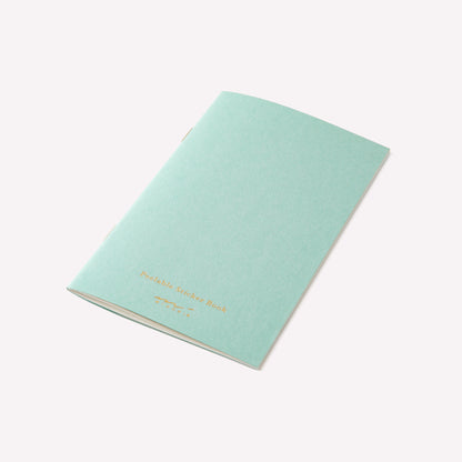 Midori peelable sticker book with a light blue cover and gold foil branding details. 