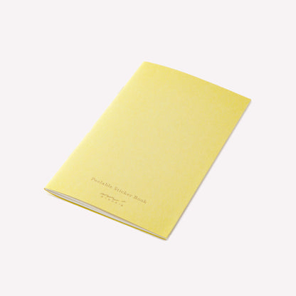 Midori peelable sticker book with a yellow cover and gold foil branding details. 