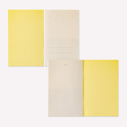 Midori peelable sticker book with a yellow cover displayed open to show the sticker release paper inside. 