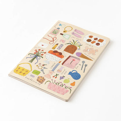 Midori My Life Yuru Log notebook featuring a beige front cover illustrated with hand drawn items like perfume, books, bags, fruit and flower designs lying on a white surface. 