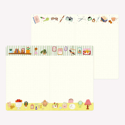 Inside the Midori My Life Yuru Log notebook. Dot grid pages are illustrated with borders featuring hand drawn picture frames, a camera, stationery, homewares and a table top scene. 