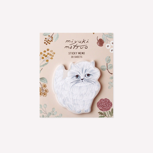 Minette cat shaped die cut sticky memo pad presented on a peach coloured floral background. 