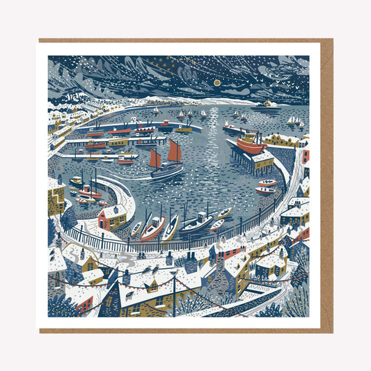 An illustrated greetings card by Matt Johnson, featuring his 'Newlyn in the Snow' Christmas artwork. The square card is paired with a kraft brown envelope.