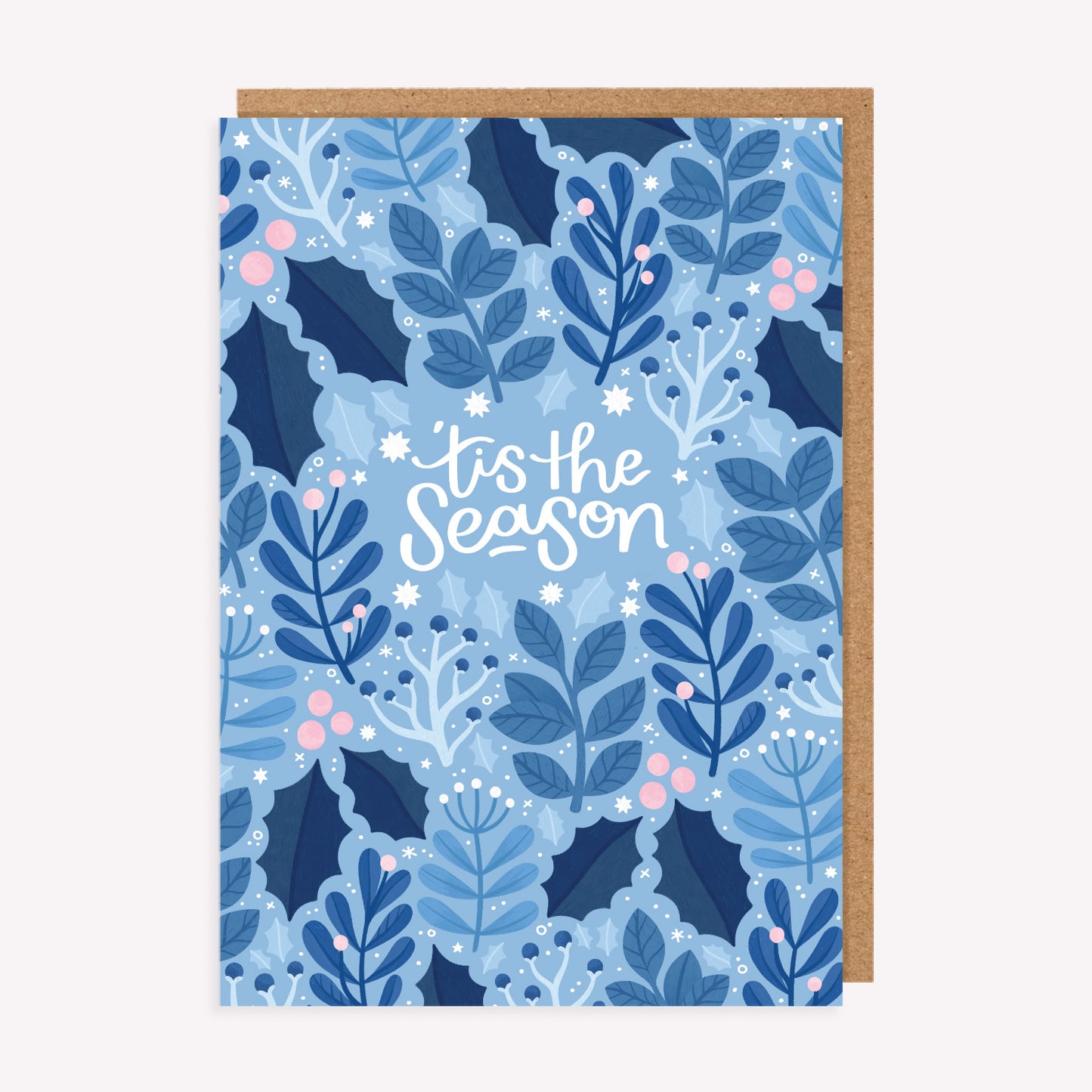 Christmas greetings card with an icy blue pattern of winter leaves and handwritten text reading 'tis the season', paired with a kraft envelope. 