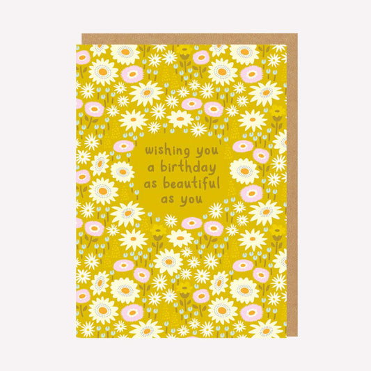 An illustrated greetings card by Elizabeth Olwen, printed by Ohh Deer. This card features a pattern of pink, white and blue flowers on a mustard yellow background, with text that reads “Wishing You A Birthday As Beautiful As You Are”.
