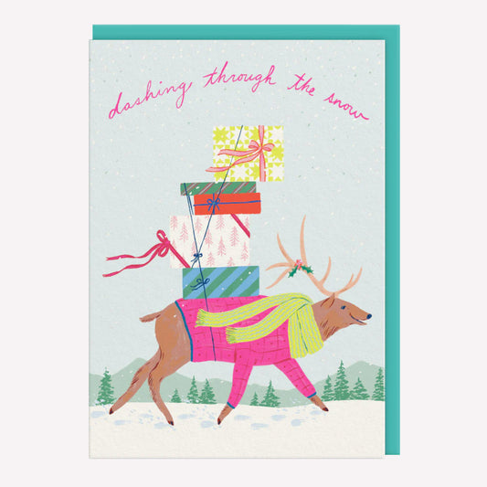 Christmas greetings card featuring an illustrated reindeer carrying a pile of presents through a snowy scene with an aqua envelope. Text reads "Dashing through the snow."
