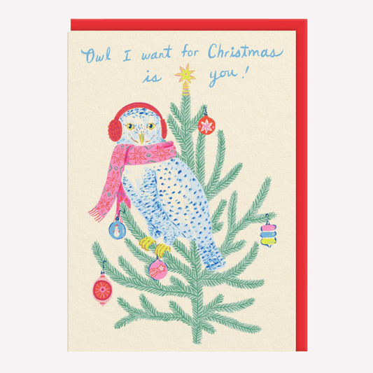 Christmas greetings card featuring an illustrated owl wearing a scarf sitting on a decorated tree with a poppy red envelope. Text reads "owl I want for Christmas is you."