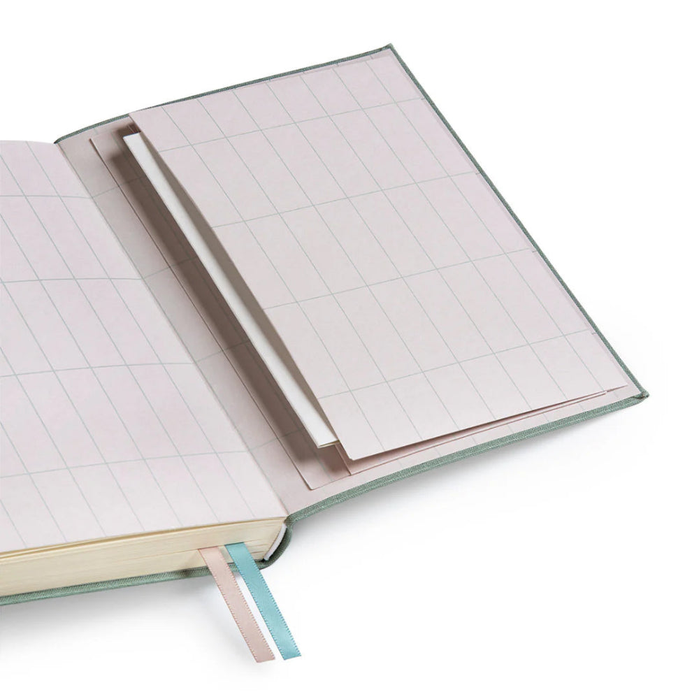 The back pages of Ohh Deer's sage blue daily planner, with a gridded pattern and a pocket for important documents.