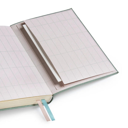 The back pages of Ohh Deer's sage blue daily planner, with a gridded pattern and a pocket for important documents.