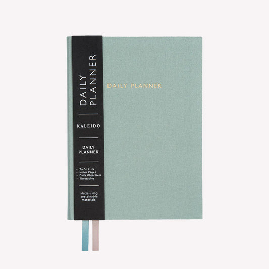 Undated daily planner by Ohh Deer, with a sage blue fabric cover and the words "Daily Planner" in gold foil text.