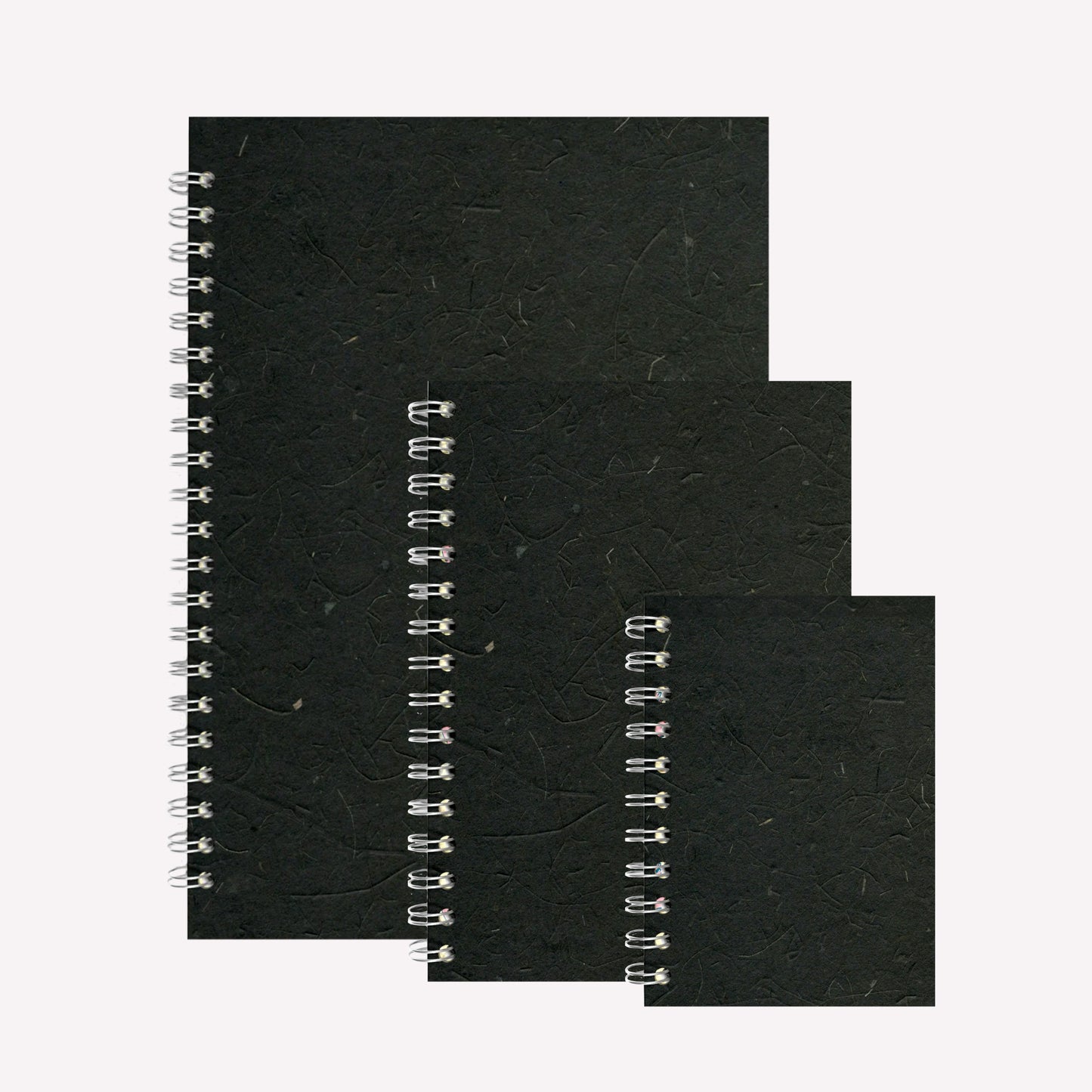 Three portrait, wire bound sketchbooks made by Pink Pig with an ebony cover made from Thai banana tissue paper.Available in A4, A5 and A6. 