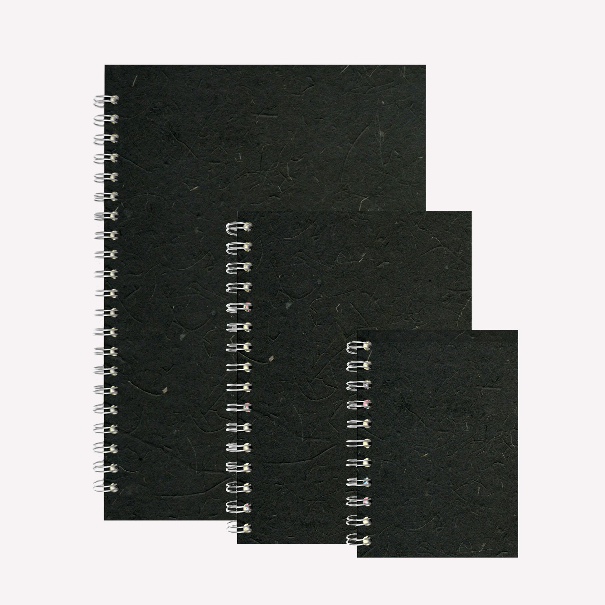 Three portrait, wire bound sketchbooks made by Pink Pig with an ebony cover made from Thai banana tissue paper.Available in A4, A5 and A6. 