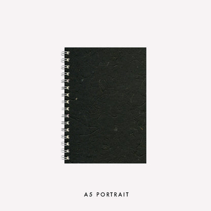 A5 wire bound portrait sketchbook made in the UK by Pink Pig with an ebony coloured banana tissue paper cover and strudy grey board backing.