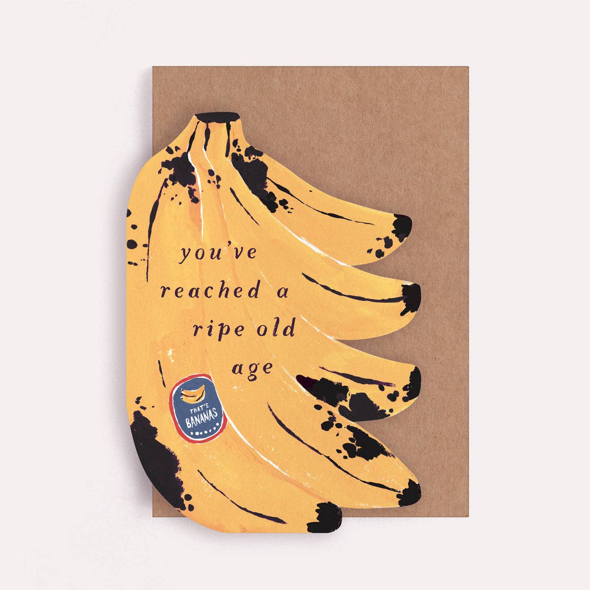 An illustrated birthday greetings card by Sister Paper Co in the shape of a bunch of bananas and text that reads "You've Reached A Ripe Old Age".