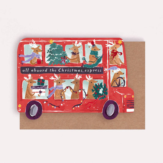 An illustrated Christmas card by Sister Paper Co in the shape of a red bus, with reindeers taking part in various Christmas decorating tasks in the windows and text that reads "All Aboard The Christmas Express".