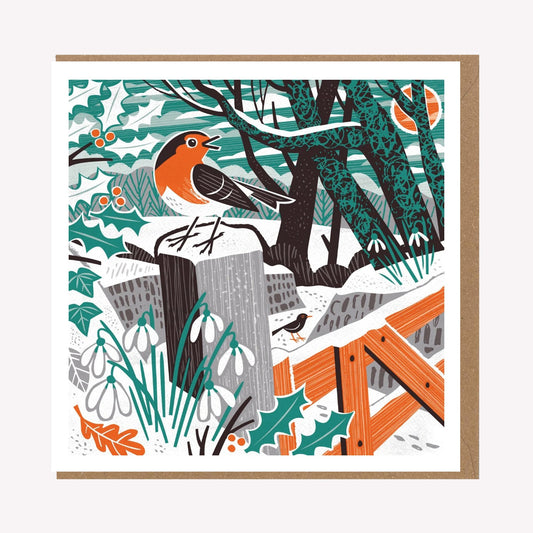 An illustrated greetings card by Matt Johnson, featuring his 'Robin & Snowdrops' Christmas artwork. The square card is paired with a kraft brown envelope.