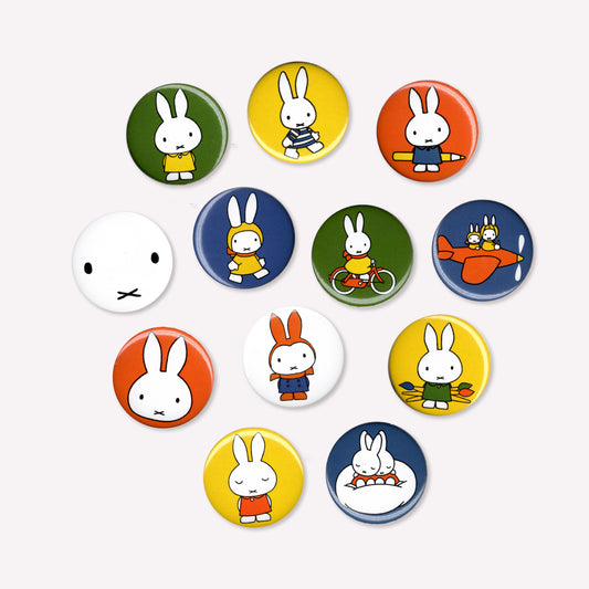 12 individual button pin badges with various Miffy cartoon designs, including Miffy with art supplies, riding a bike, flying a plane and snugging in bed. 