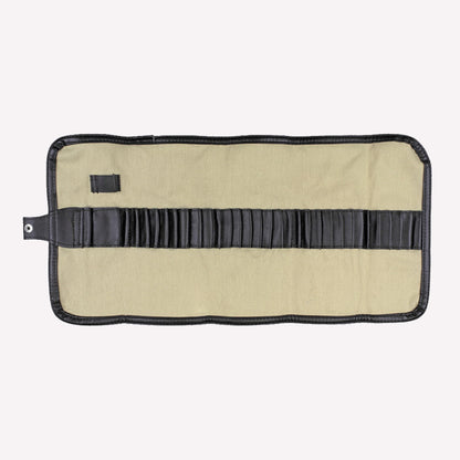 Natural canvas pencil and brush wrap made from cream coloured material with a brown strap, unrolled to display room to store tools and art materials. 