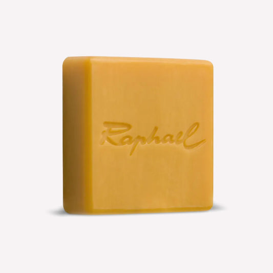 Raphael 100g natural soap bar for cleaning, conditioning and preserving artists's paintbrushes. Yellow soap bar features branding engraved into surface. 