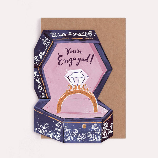 Illustrated die cut greetings card with an engagement ring box design and text reading "you're engaged." 