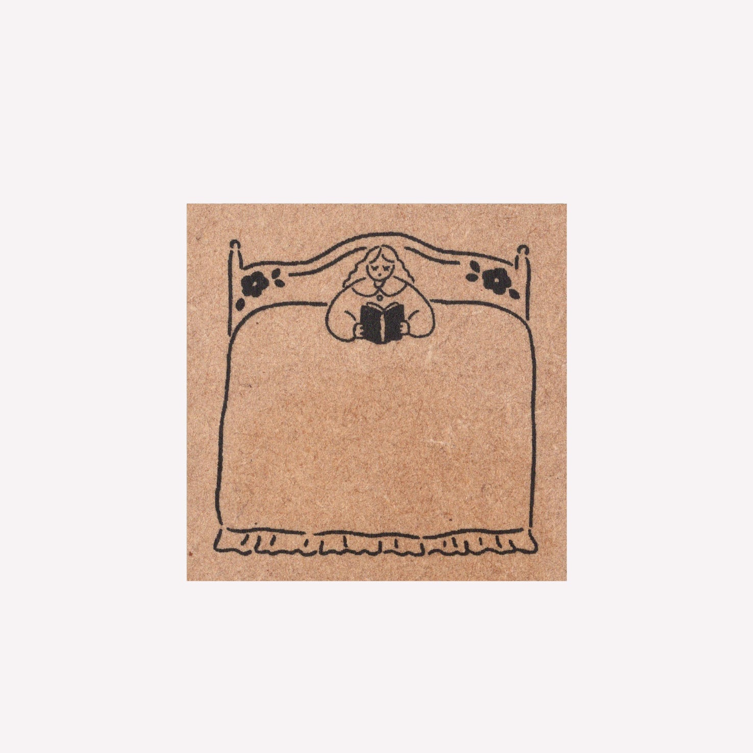 Rubber journalling stamo with a frame design of a girl reading in bed. 