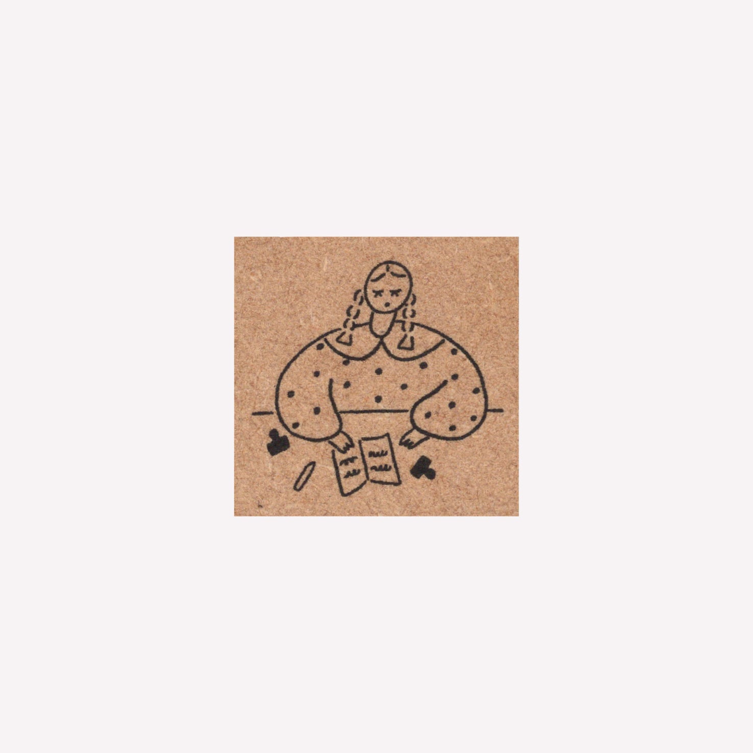 Rubber journalling stamp with a design of a girl journalling at a desk. 