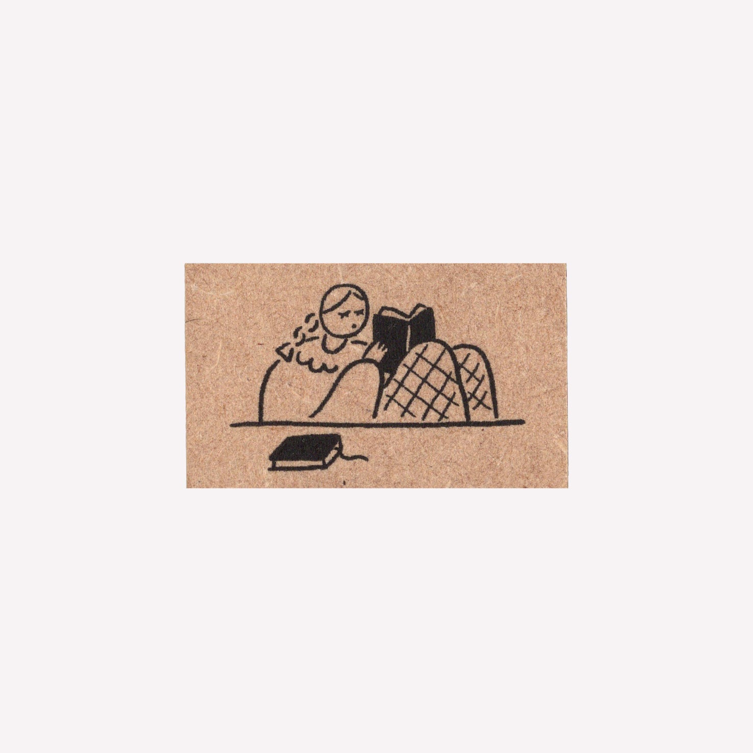 Rubber journalling stamp with a design of a girl reading a book. 